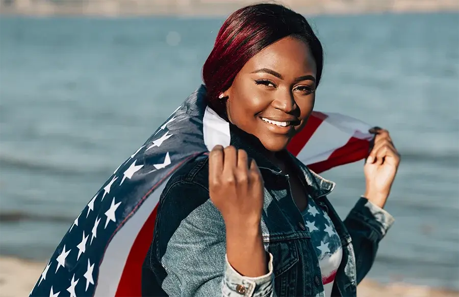 african american woman holding american flag and smiling